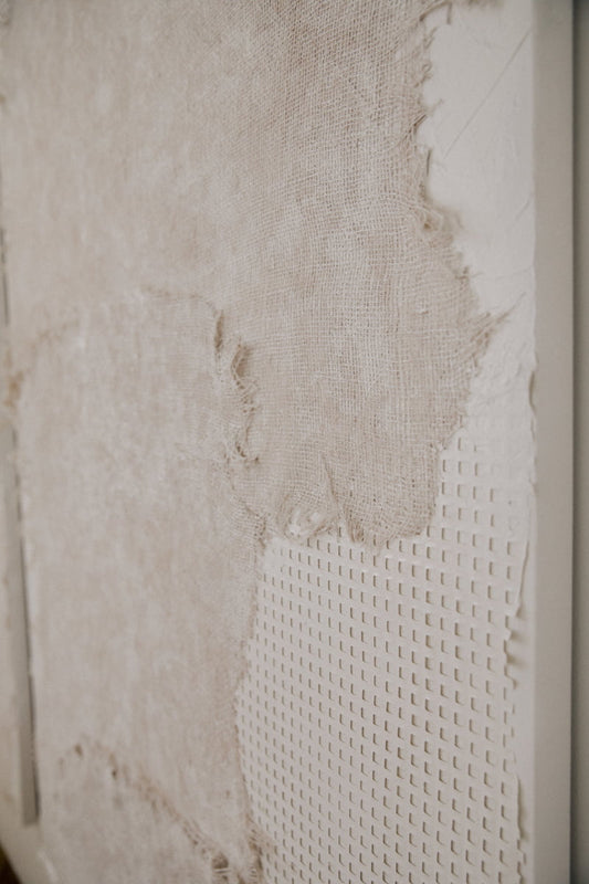 Close-up of Art By Suzette Newman canvas art, featuring textured layers of rough, torn beige fabric over a subtle grid pattern. Side angle emphasizes handmade details, rich texture, and depth.