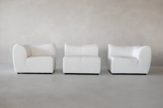 The Bambon 3 Piece Sofa Set features three modern white chairs with curved edges arranged side by side against a light grey backdrop—an ideal minimalist addition for any contemporary living space.