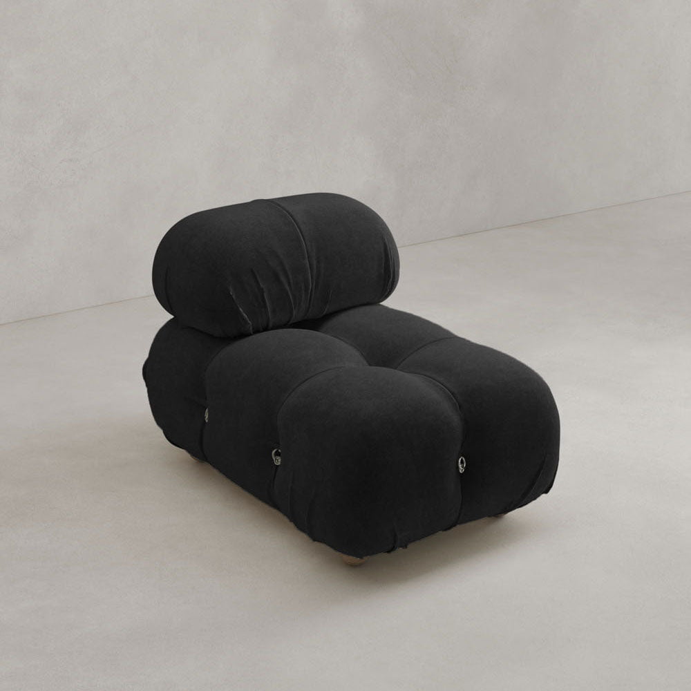 The Belmont Chair 2/3Rd Modular Sectional features marshmallow-like curves and black upholstery, sitting on a light-colored floor against a neutral wall.