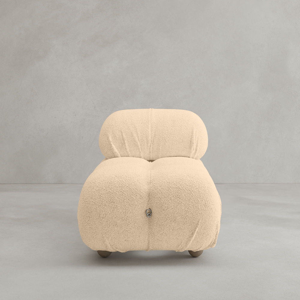 The Belmont Chair 2/3Rd Modular Sectional, upholstered in cream textured fabric with plush, rounded cushions and low wooden legs, exudes iconic classic charm against a light gray background.