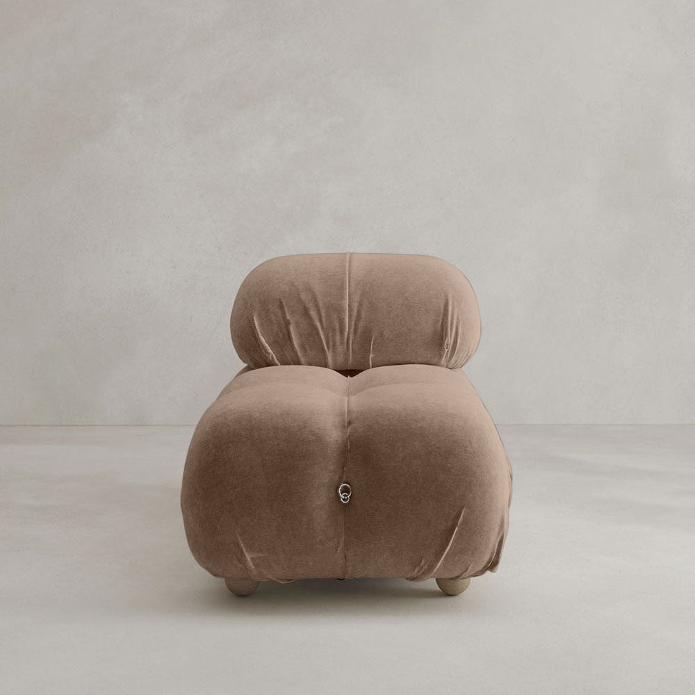 The Belmont Chair 2/3Rd Modular Sectional features a plush, rounded design with deep tufting, upholstered in soft brown fabric, and supported by short legs. Its modern, armless silhouette is set against a plain light gray background.