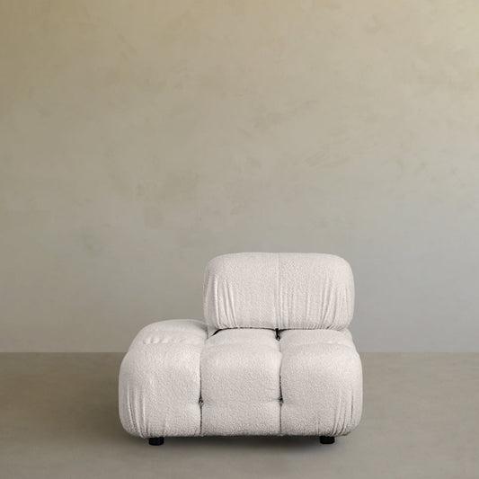 The Belmont Sofa 2/3Rd Backrest features a modern, armless design with tufted, cushioned seating and soft textured white upholstery for a cloud-like feel, ideal against neutral-toned walls and gray flooring.