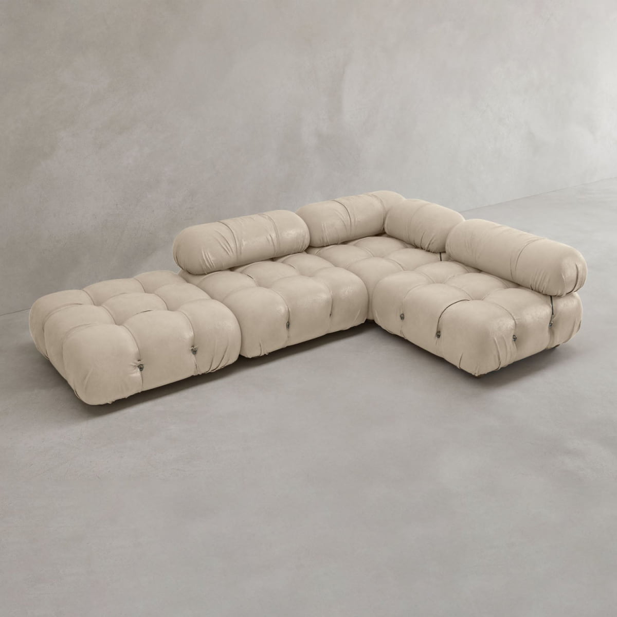 The Belmont Sofa Combination C is a modern, beige L-shaped sectional with tufted upholstery, marshmallow-like curves, and rounded cushioned arm and backrests, displayed against a plain light gray background.