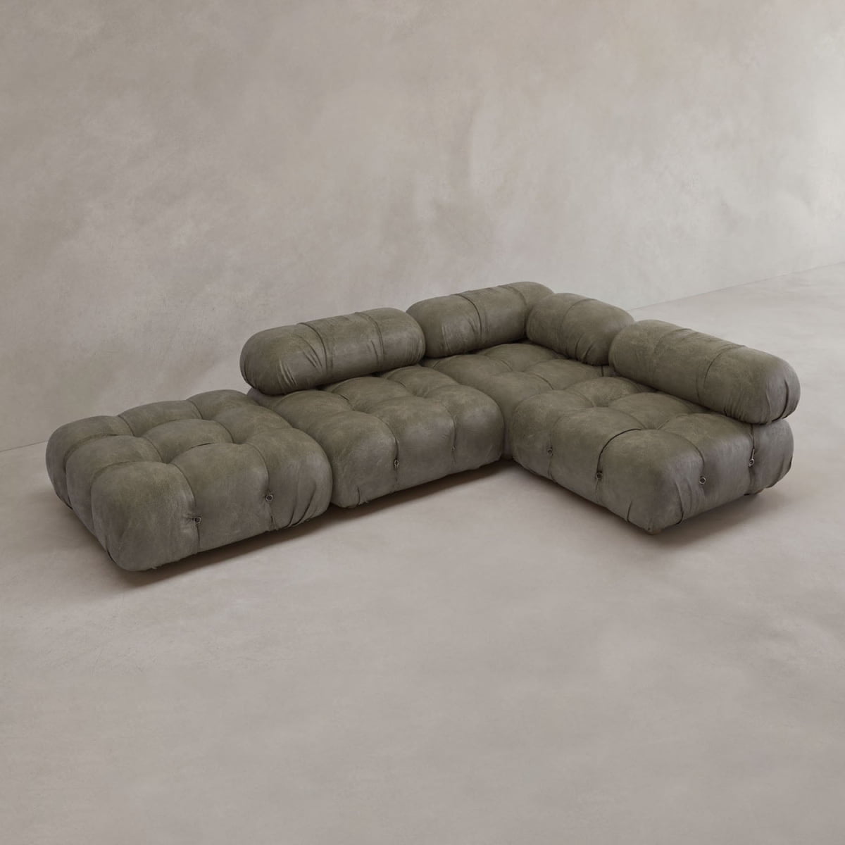 The Belmont Sofa Combination C features a modern, modular L-shaped design with tufted olive-green cushions, low backs, and marshmallow-like curves set against a light-toned minimalist backdrop.