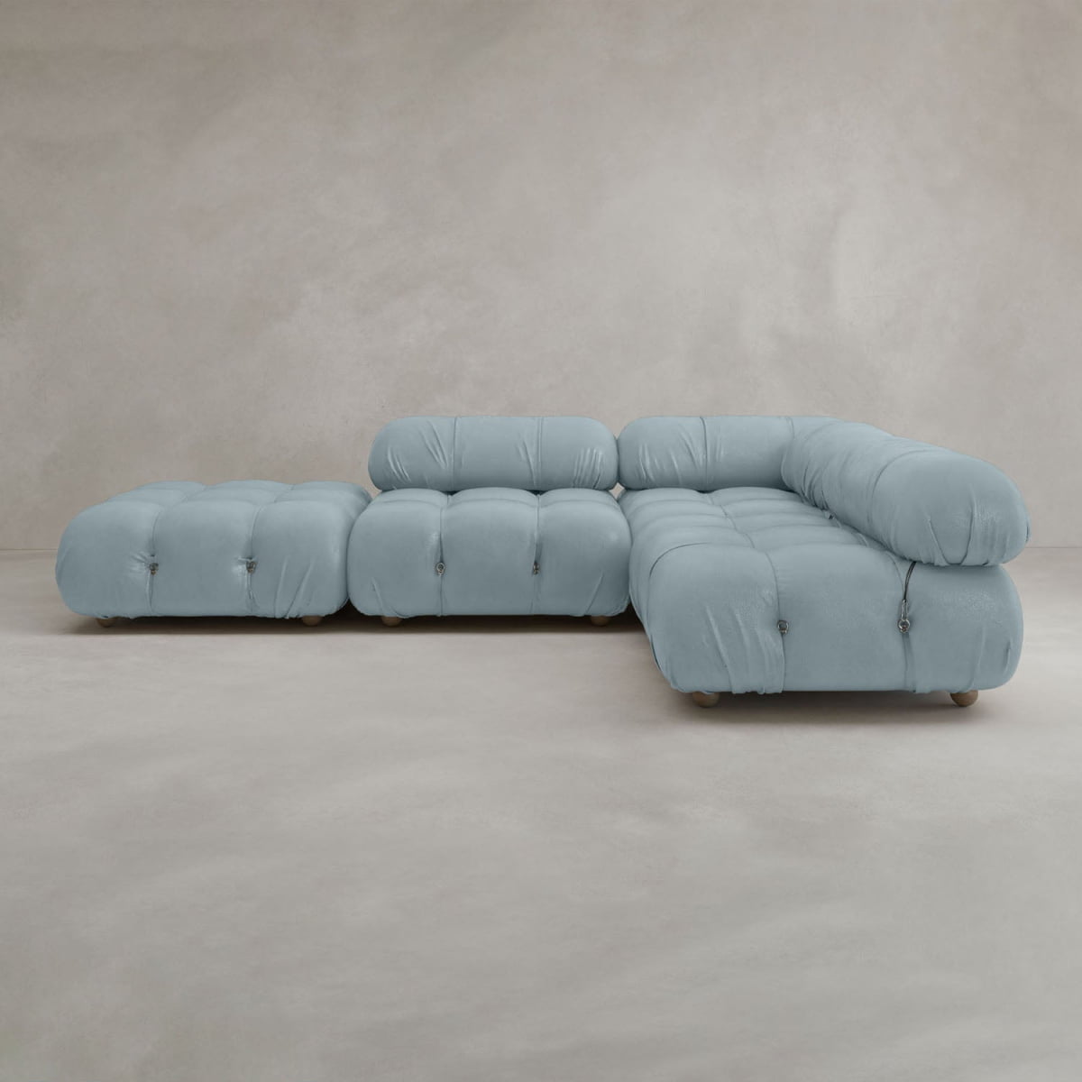 The Belmont Sofa Combination C is a light blue, tufted sectional with marshmallow-like curves, plush cushions, and a modern minimalist modular design featuring three main seating sections set against a plain light beige background.