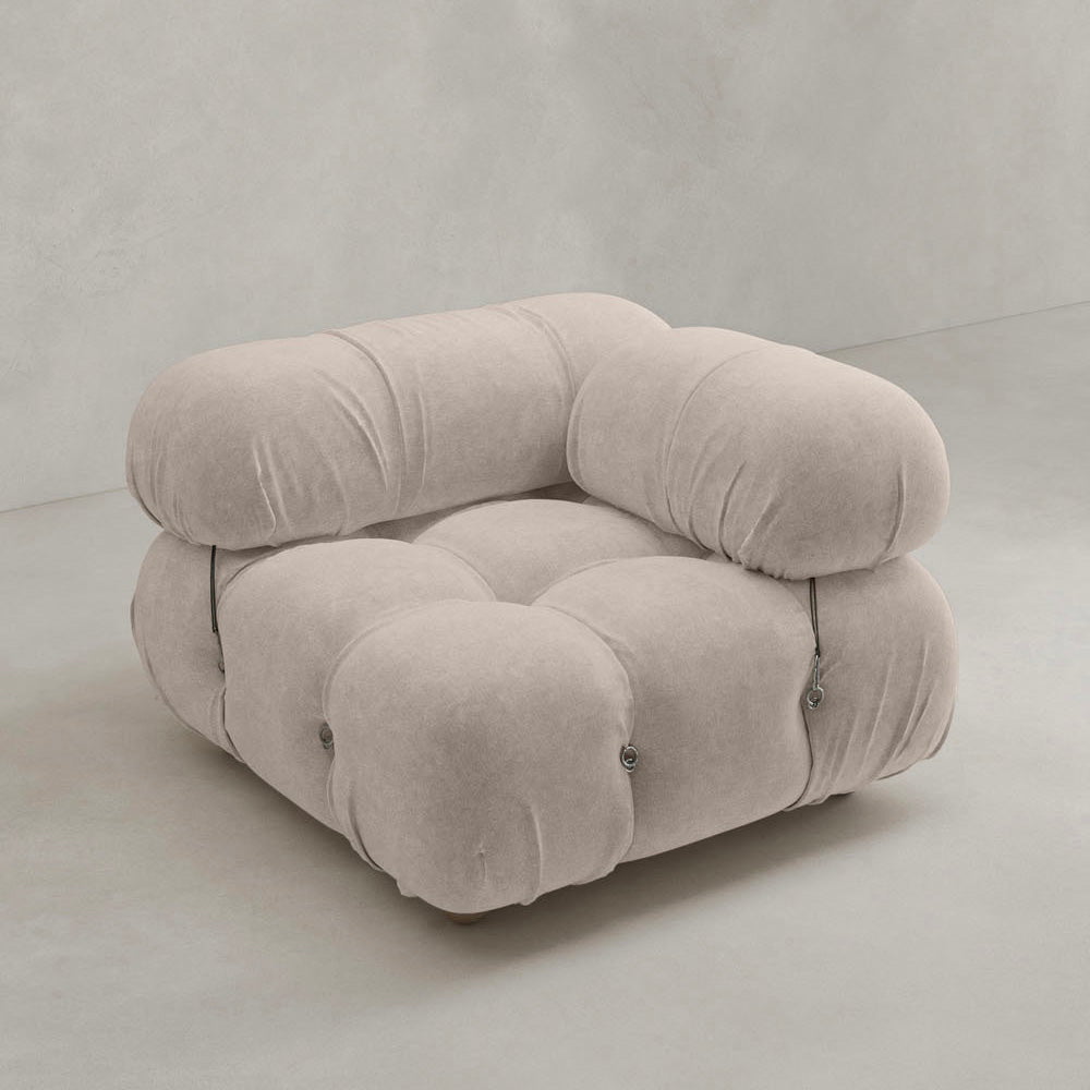 The Belmont Sofa Left Armrest features marshmallow-like curves, plush rounded cushions, tufted buttons, and visible metal fasteners on the sides in light beige upholstery, all set against a plain light-colored background.