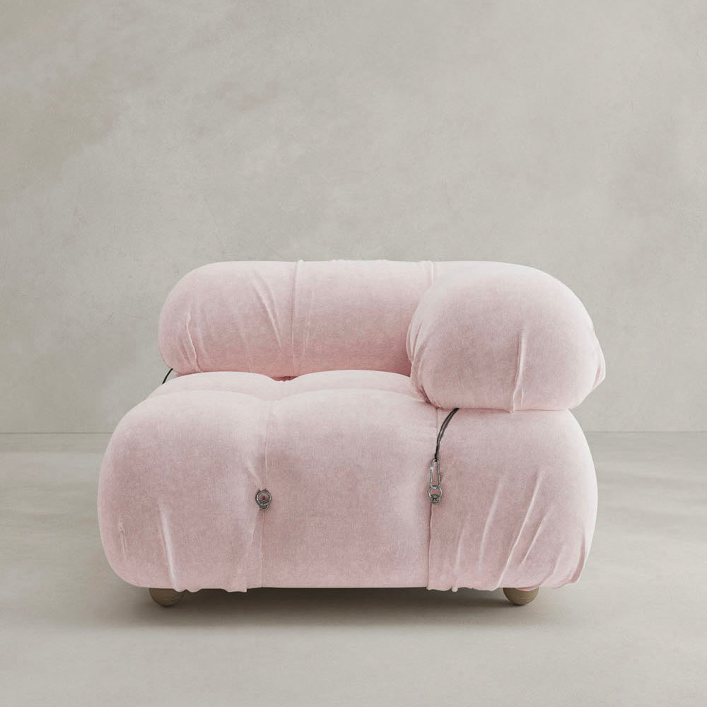 The Belmont Sofa Left Armrest is a modern, plush seat with soft pale pink upholstery, marshmallow-like curves, rounded cushions, and visible button details, pictured against a plain light background.