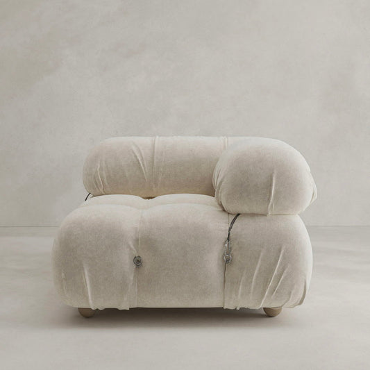 The Belmont Sofa Left Armrest is a plush, modern beige seat with rounded, overstuffed cushions and visible button tufting in a modular design, shown against a plain light-colored background.
