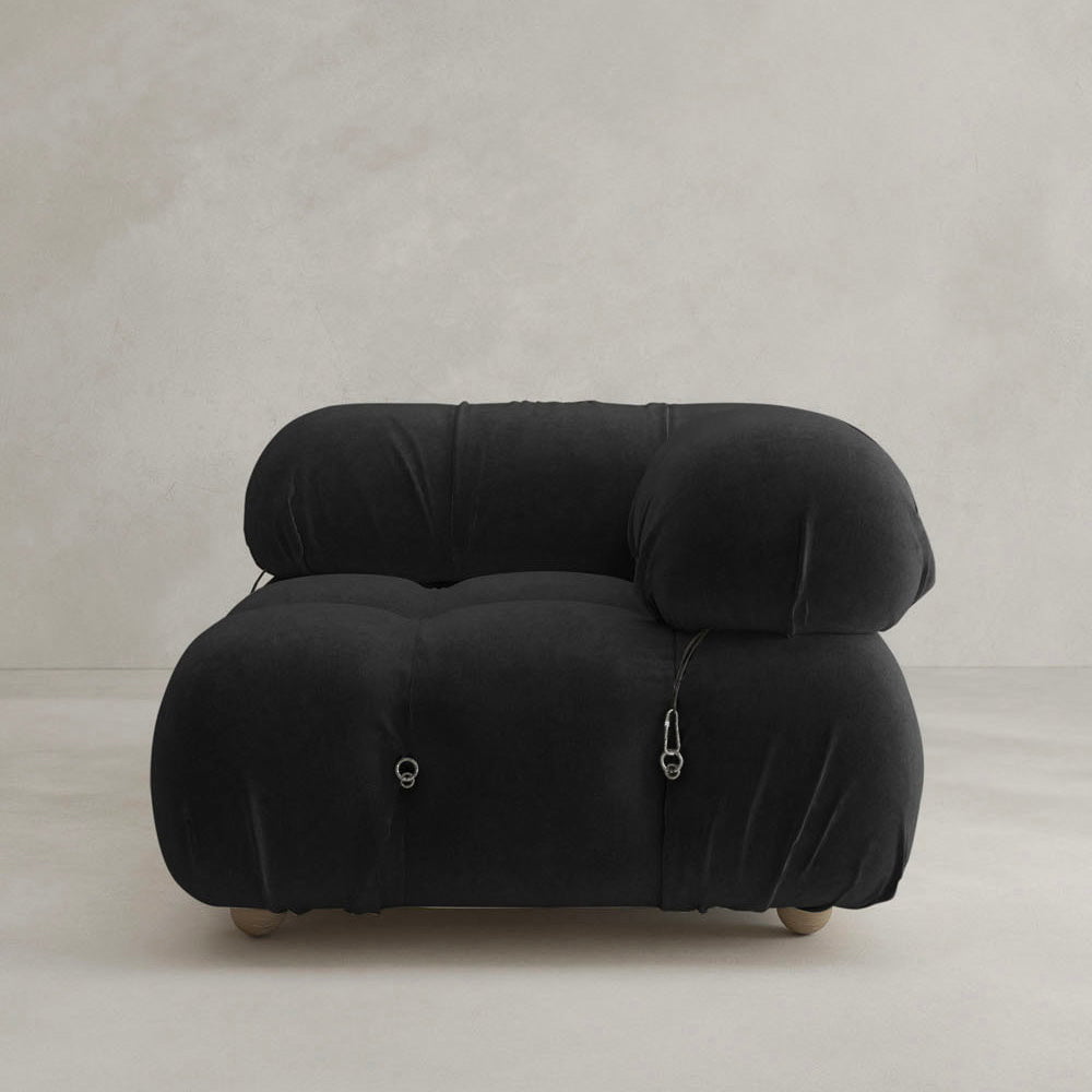 The Belmont Sofa Left Armrest features a modern, overstuffed black design with rounded edges and silver hardware, adding an iconic classic touch to any minimalist space.
