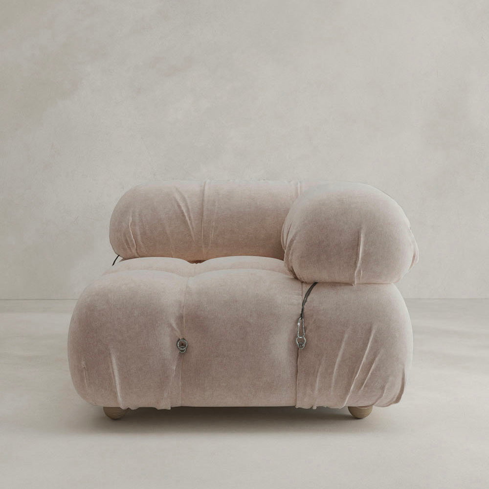 The Belmont Sofa Left Armrest features plush, marshmallow-like curves, soft upholstery, pillow-inspired design, visible straps or fasteners, and a rounded shape—an iconic classic shown against a plain, neutral background.
