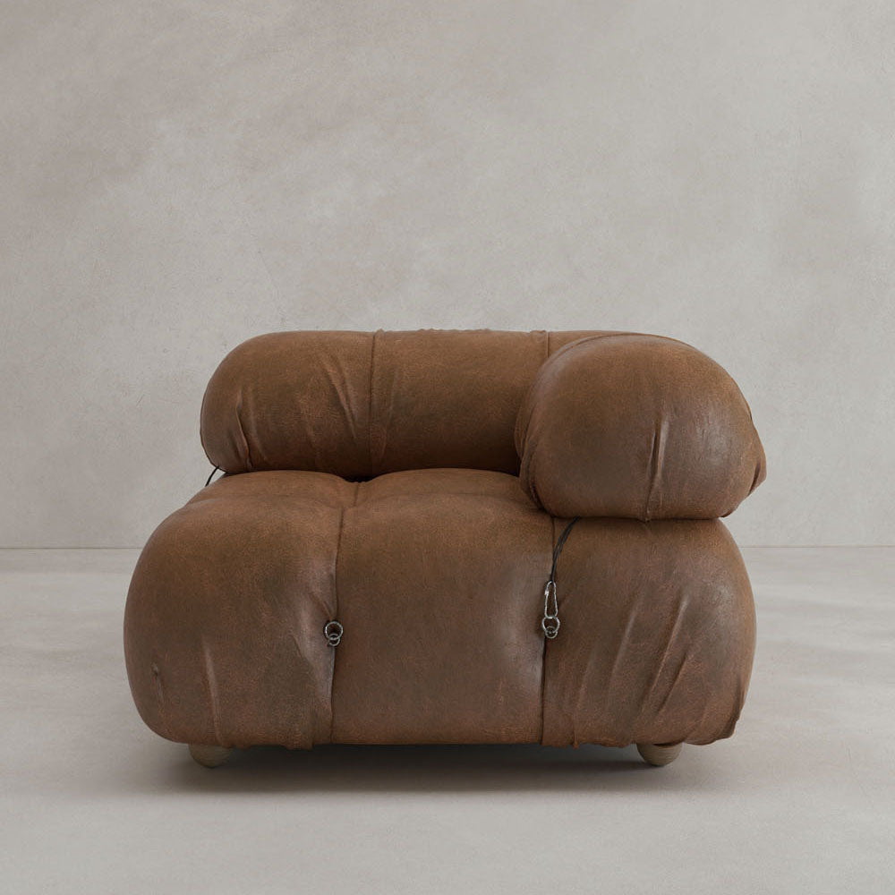 The Belmont Sofa Left Armrest features plush, oversized brown leather cushions with metal fasteners for a classic, iconic look—perfect against a light-colored wall and floor.