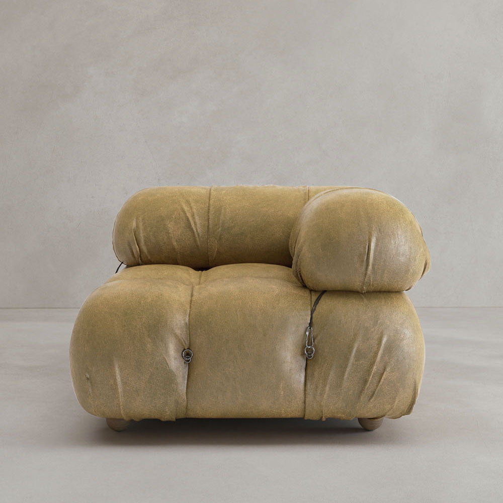 A plush, tan Belmont Sofa Left Armrest with rounded, overstuffed cushions and visible metal fasteners showcases a modular design against a plain light gray background.