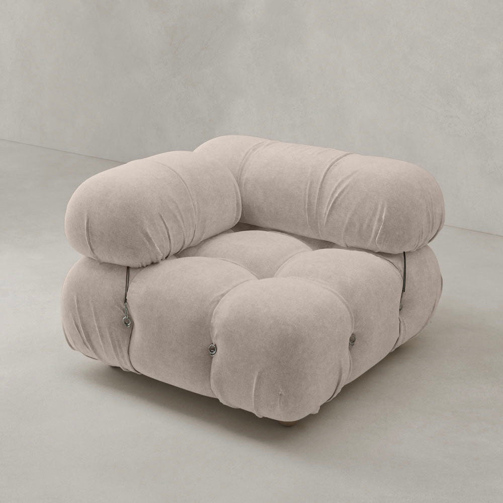 The Belmont Sofa Right Armrest features modern, oversized design with soft, tufted light beige upholstery and rounded cushions in iconic classic style, set against a plain, light-colored background.