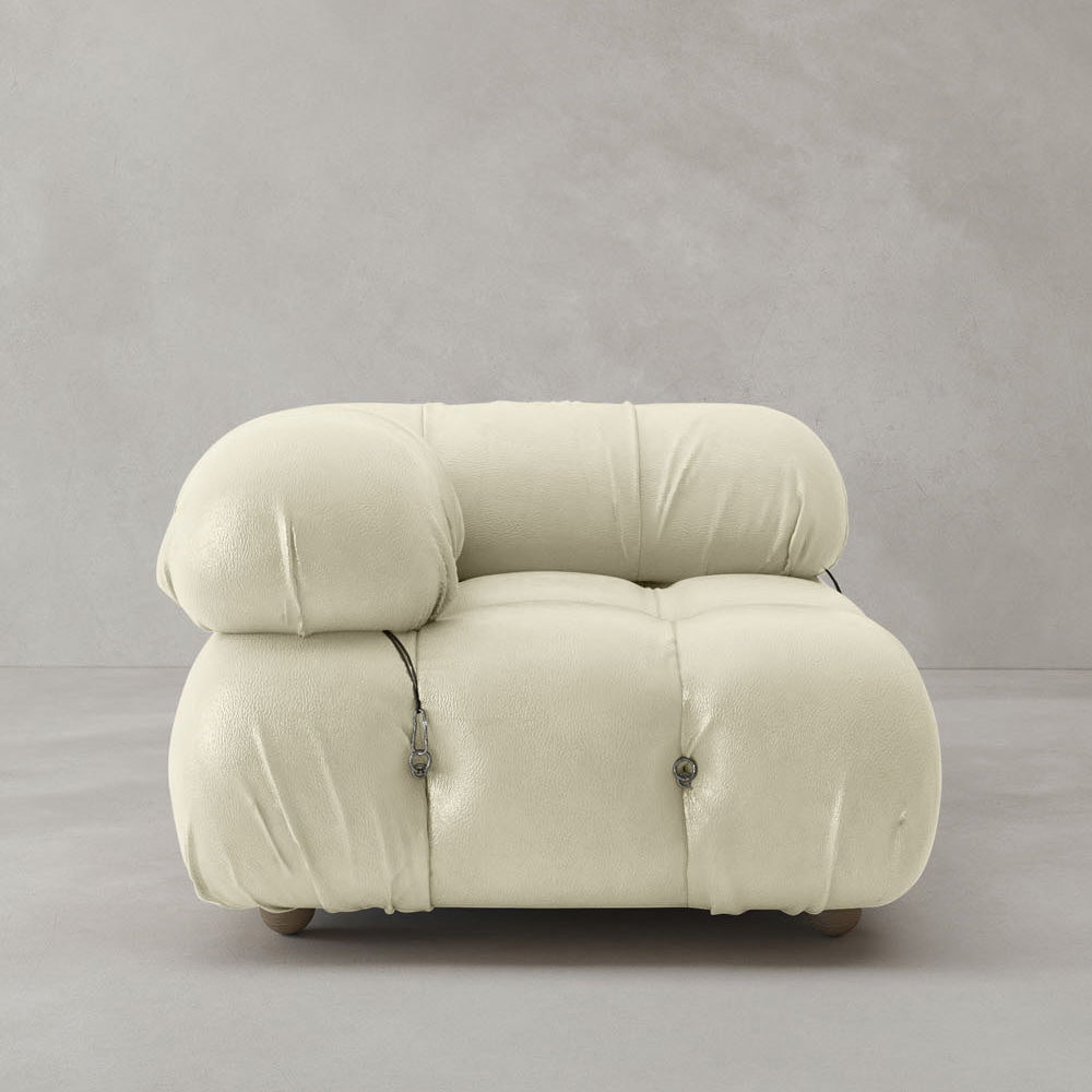 The Belmont Sofa Right Armrest is a modern, oversized piece with plush, rounded cushions in off-white fabric, visible seams, and side metal buckle details—an iconic classic set against a plain light gray background.