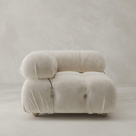 The Belmont Sofa Right Armrest, in plush light beige with soft rounded cushions and exposed metal fasteners, exemplifies modular design against a plain, light background.