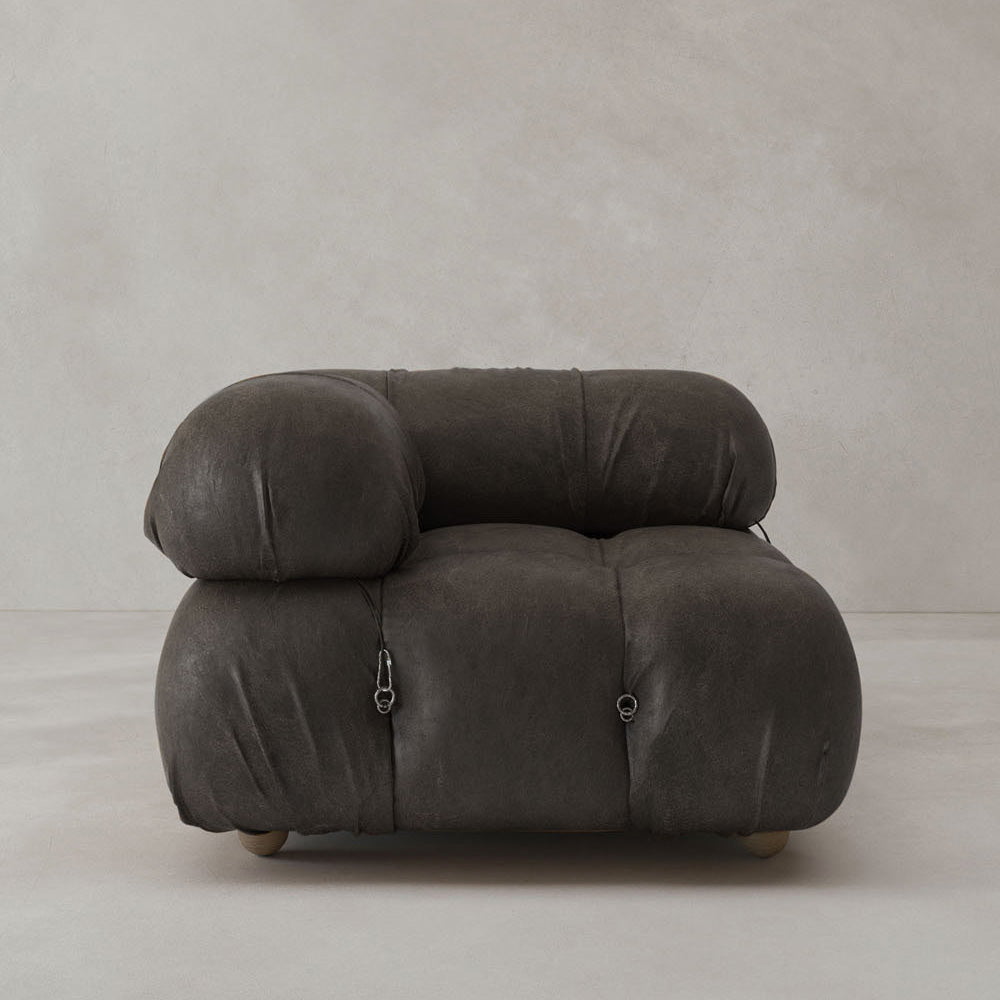 The Belmont Sofa Right Armrest features a modern, oversized design with rounded, padded cushions and dark, textured upholstery, bringing iconic classic style to any interior against a plain, light-colored background.