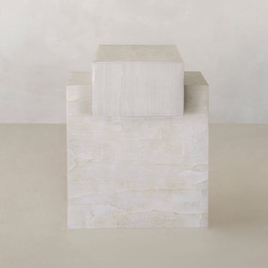The Bianca Short is a minimalist sculpture featuring two stacked rectangular blocks, the smaller atop a larger White Onyx Plinth, both with a smooth light beige texture and natural luminosity set against a neutral background.