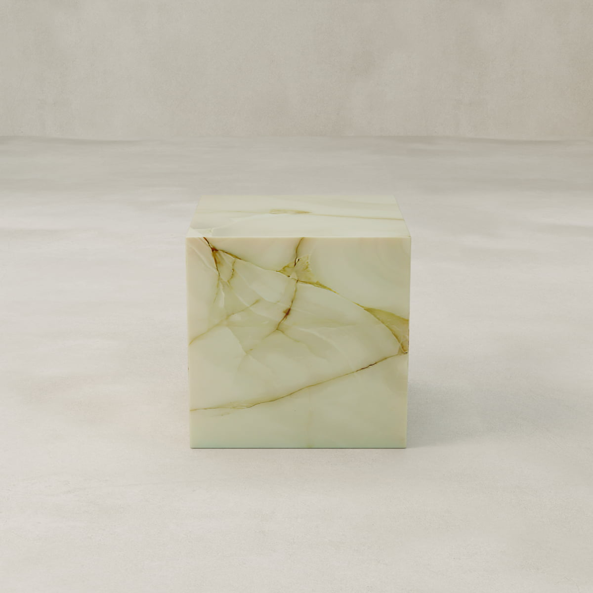 The Blanchaire Onyx Plinth - Cube features light green marble onyx with brown and gold veining, set on a smooth, pale surface against a neutral background—a striking sculptural accent for any space.
