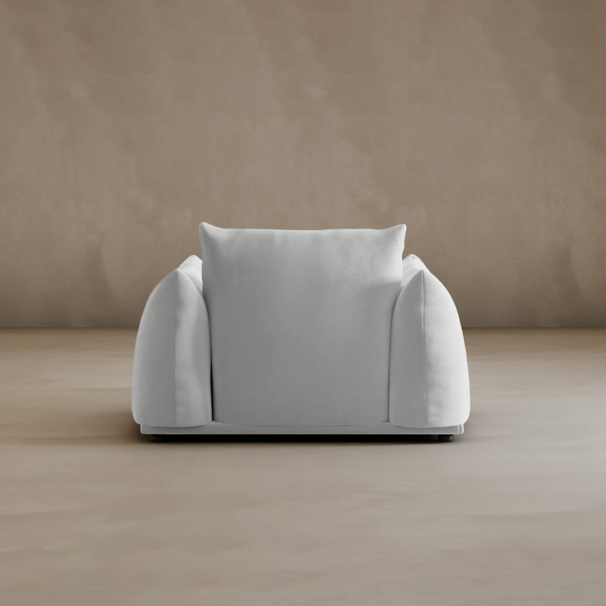 The Calypso Arm Chair features rounded sides and a plush back cushion, radiating modern elegance on a smooth beige floor beside a matching beige wall.
