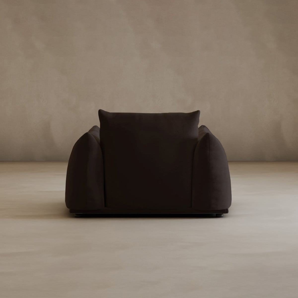 The Calypso Arm Chair exudes modern elegance, its dark brown tones and plush comfort standing out in a minimal beige room with plain textured walls and floors.