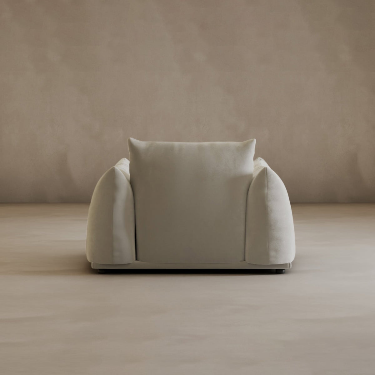 The Calypso Arm Chair, featuring a modern minimalist design, is upholstered in light beige fabric with wide armrests and a plush backrest, offering elegant comfort against a matching beige wall and floor in a simple, empty room.