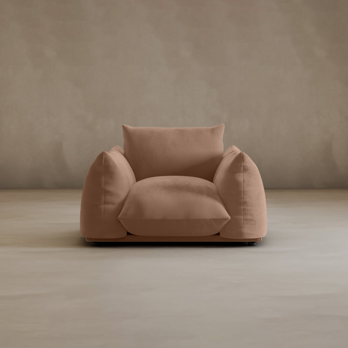 The Calypso Arm Chair, large and light brown with wide overstuffed cushions, sits on a smooth beige floor against a taupe wall, facing forward and radiating plush comfort for a cozy, inviting look.