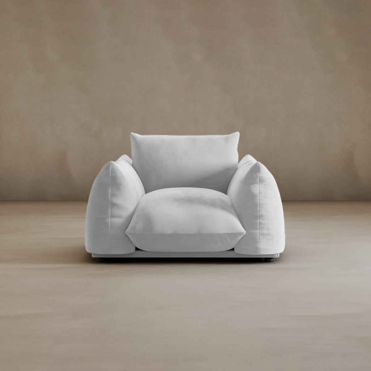 The Calypso Arm Chair features a modern, oversized design with plush, rounded cushions, providing comfort as it rests on a light beige floor against a matching beige wall.