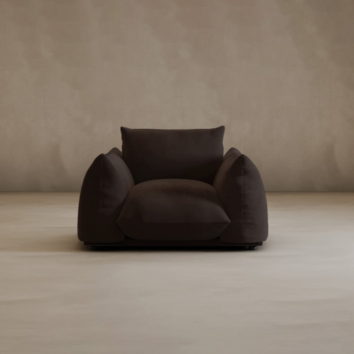 The Calypso Arm Chair adds modern elegance to any room, featuring plush comfort and oversized cushions, shown here on a light beige floor against a textured beige wall.