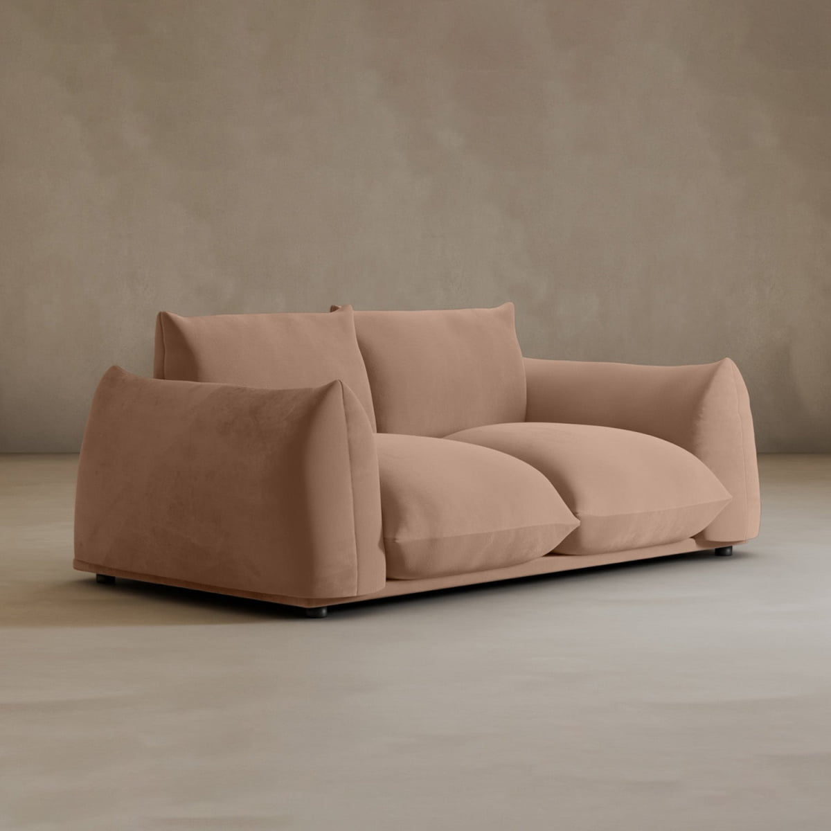 The Calypso Loveseat exudes modern elegance with its oversized, light brown plush cushions and soft, rounded edges, resting on a smooth, neutral-colored floor against a beige wall.