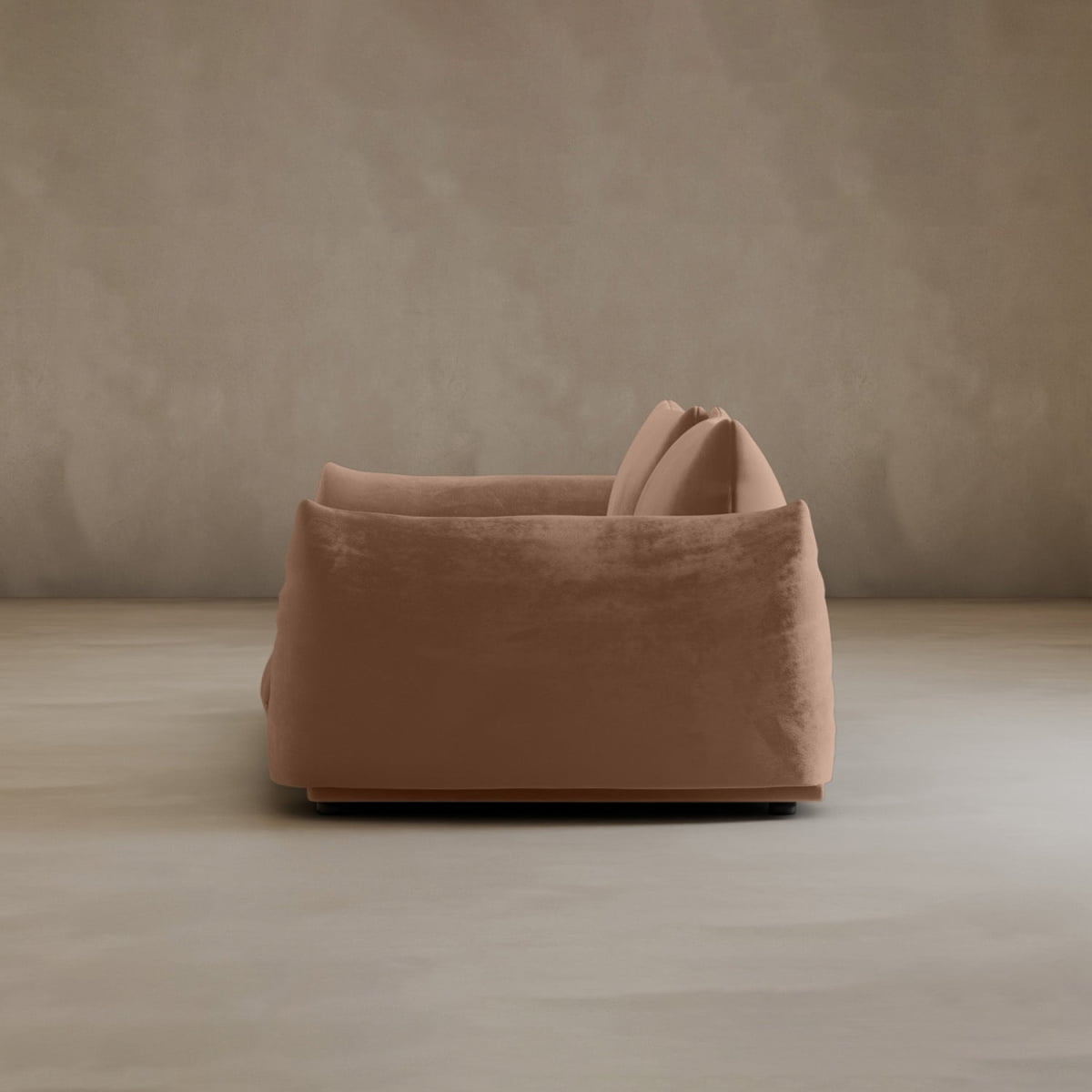 A modern, plush light brown Calypso Loveseat with two cushions is shown from the side, exuding contemporary elegance in a minimalist room with neutral-toned walls and flooring.