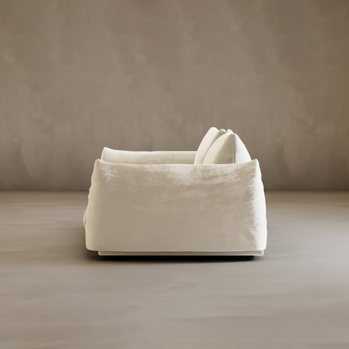 The Calypso Loveseat, a modern plush white 2-seater with two large cushions, is seen from the side against a plain beige background, radiating contemporary elegance.