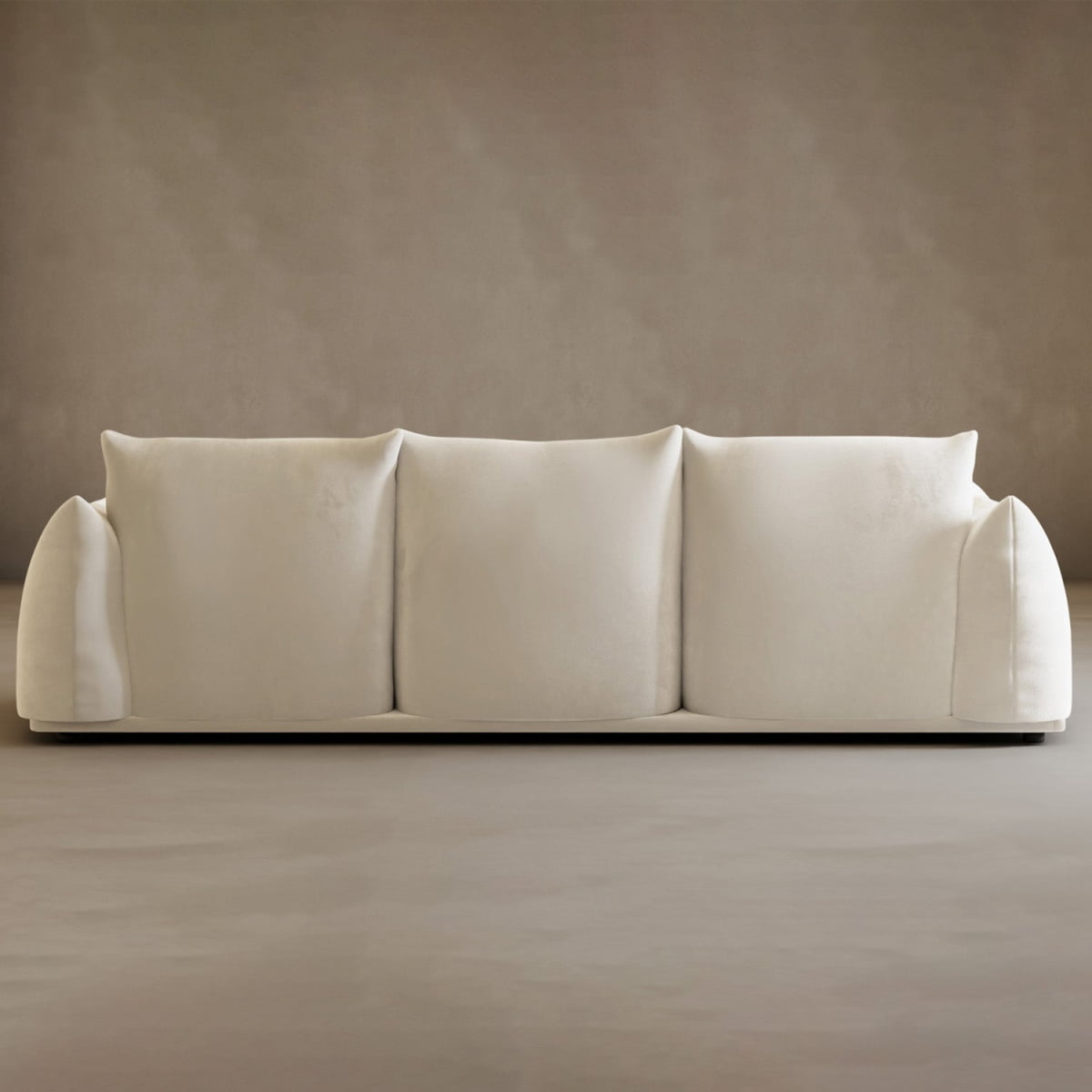Experience modern elegance with the Calypso Three Seater Sofa, a cream-toned three-seater with plush comfort and rounded arms, showcased against a plain light brown wall and floor.