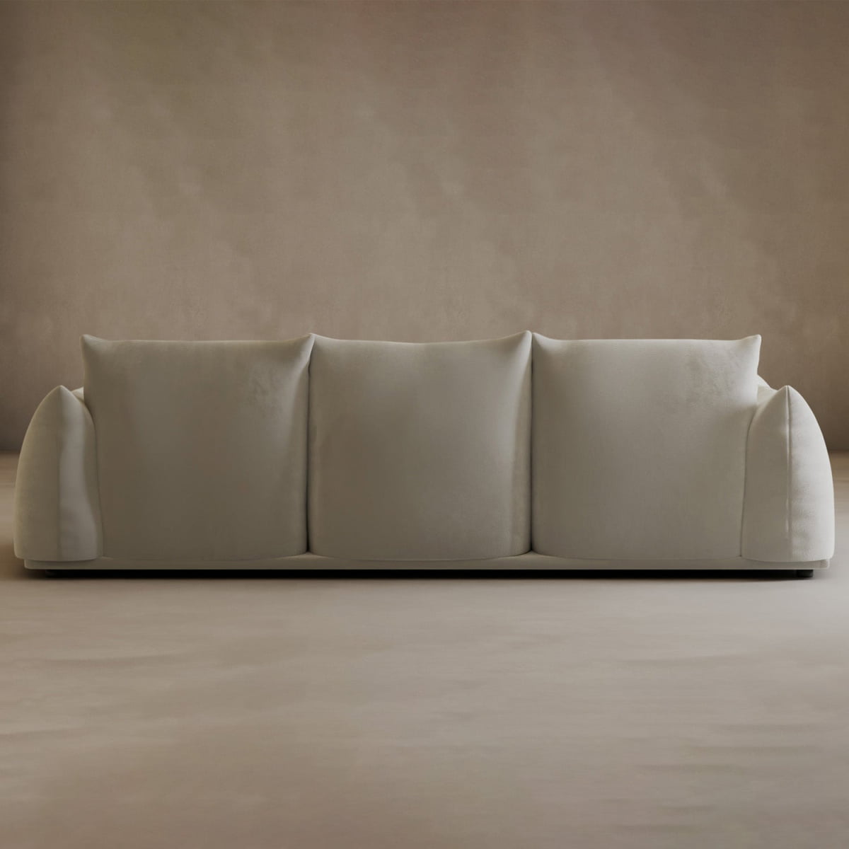The Calypso Three Seater Sofa is a minimalist, modern piece with three large back cushions and rounded armrests, perfect for any living room and beautifully complementing beige walls and floors.