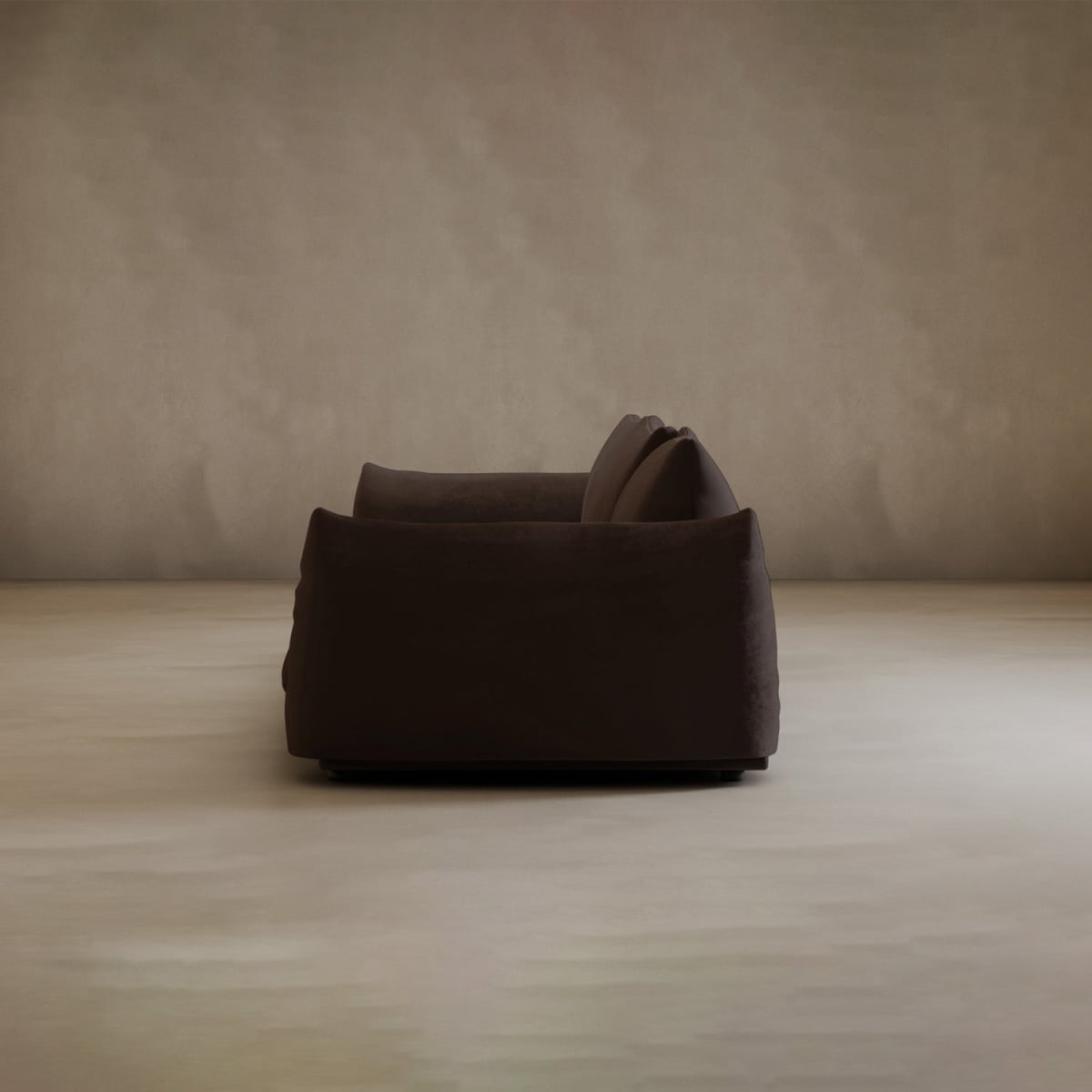 The Calypso Three Seater Sofa, shown from the side in a minimal room with beige walls and a light floor, features plush cushions—a perfect modern sofa choice for stylish living room furniture.