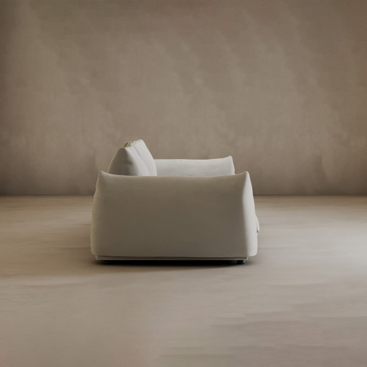 The Calypso Three Seater Sofa, featuring plush white cushions, is centrally placed in an empty room with beige walls and floor—an inviting modern addition to any living room furniture collection.