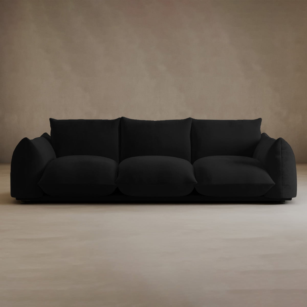 The Calypso Three Seater Sofa features deep cushions and low armrests, creating a modern, inviting centerpiece for your living room when placed on a light floor against a beige wall.