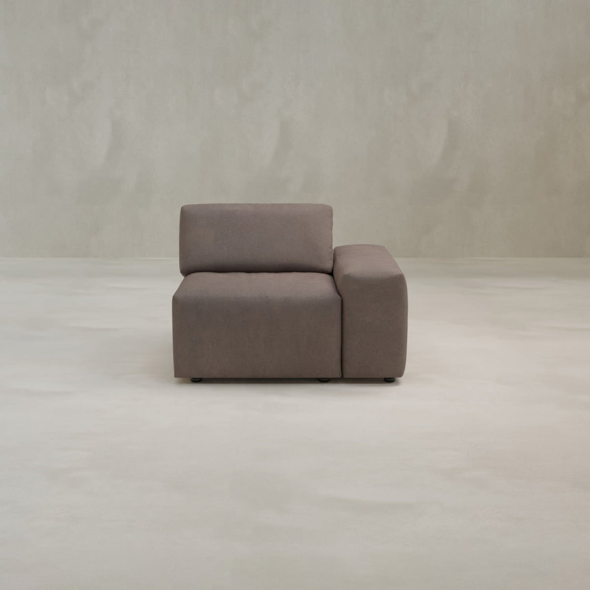 The Canonbury Left Armrest is a modern, minimalist brown armchair with a left-side armrest, set against a plain, light backdrop—perfect for contemporary comfort and style.