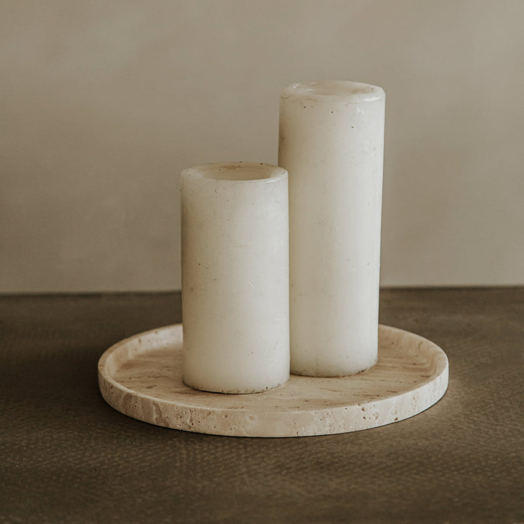 Two white pillar candles of varying heights rest on the Cascade Tray in Large, set against a neutral, minimalist backdrop—an effortless display of natural elegance.