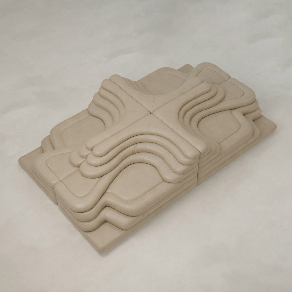 The Cascata 4 Piece Sofa Rental features layered, sculptural curves in a sand hue with geometric lines, creating a modern, abstract topography effect on a light, neutral surface.