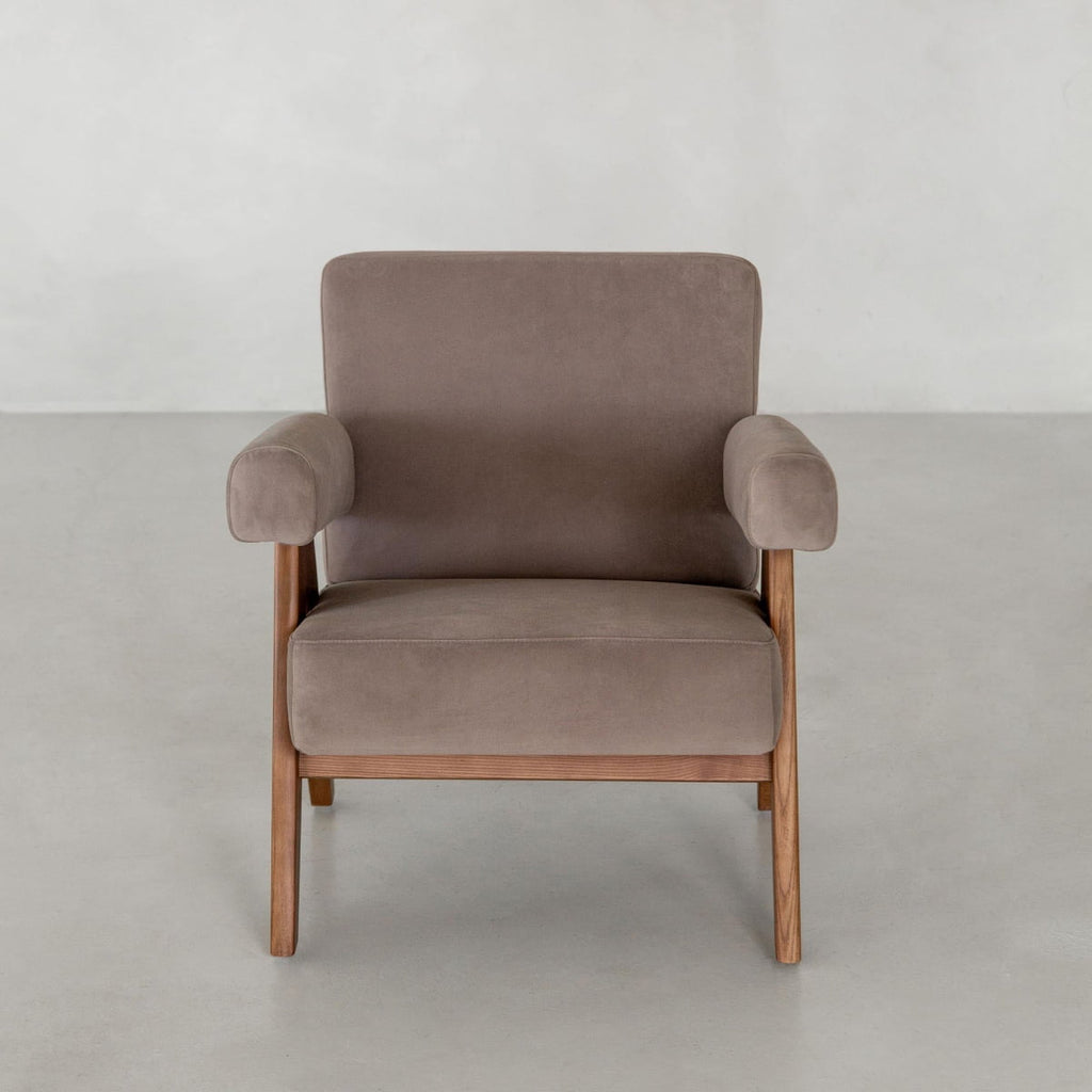 The Chelsea Lounge Chair showcases a modern, mid-century style with soft brown faux mohair upholstery and wooden legs, set against a plain light grey background.