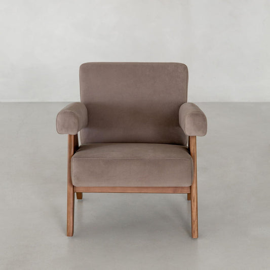 The Chelsea Lounge Chair showcases a modern, mid-century style with soft brown faux mohair upholstery and wooden legs, set against a plain light grey background.