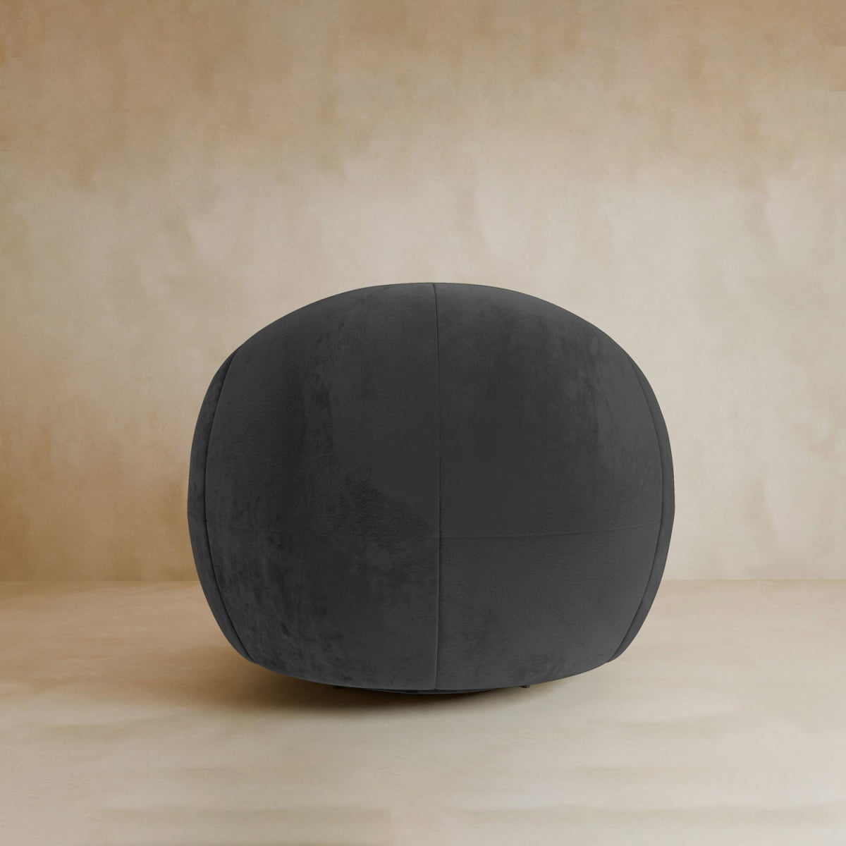 A stylish Clara Armchair with soft velvet upholstery in dark gray stands on a light beige surface against a matching beige background.