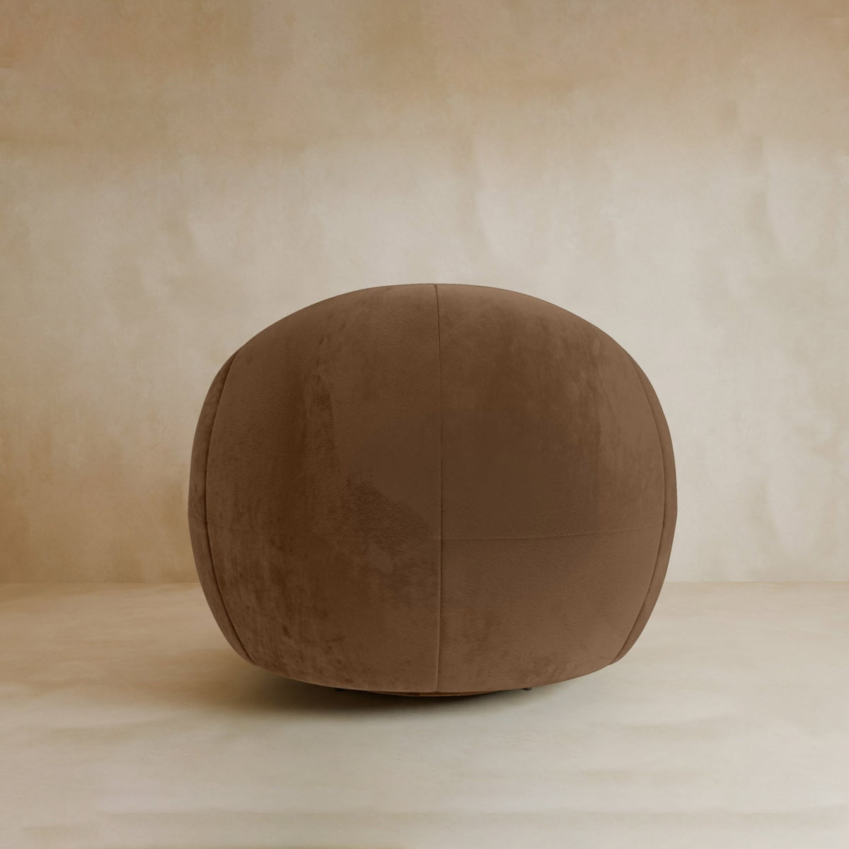 A round, brown velvet ottoman sits on a light beige surface against a matching background—perfect for pairing with the Clara Armchair in any contemporary space.