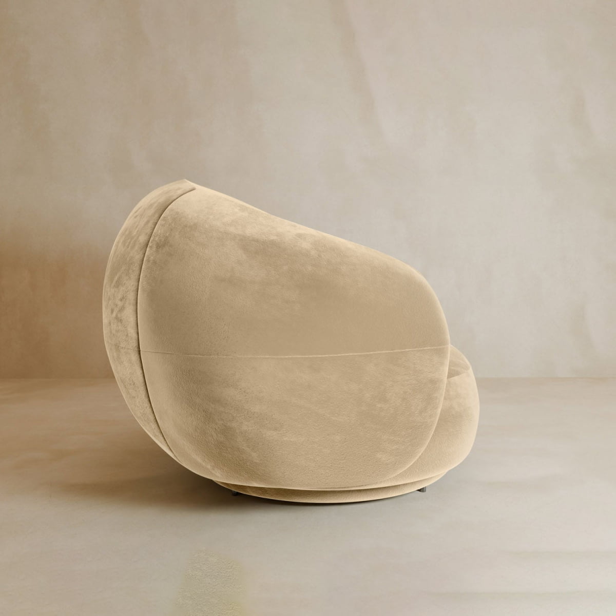 The Clara Armchair is a modern, plush beige swivel chair with velvet upholstery and a rounded, contemporary design, placed on a smooth light floor against a neutral wall.
