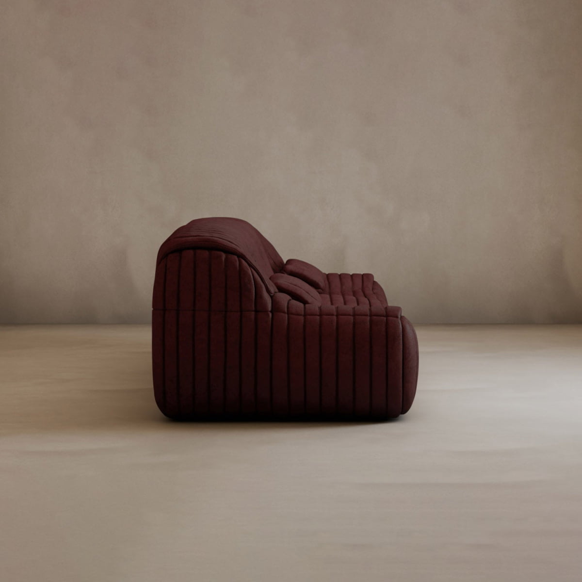 The Calypso Armchair, a deep burgundy lounge chair with tufted stripes and a low profile, stands alone against a neutral textured wall and smooth light floor, radiating modern elegance.