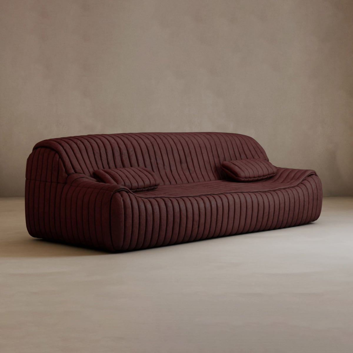 A modern, dark burgundy Calypso Armchair with two matching cushions and a ribbed, tufted stripe design sits on a light neutral floor against a plain beige wall, exuding modern elegance.