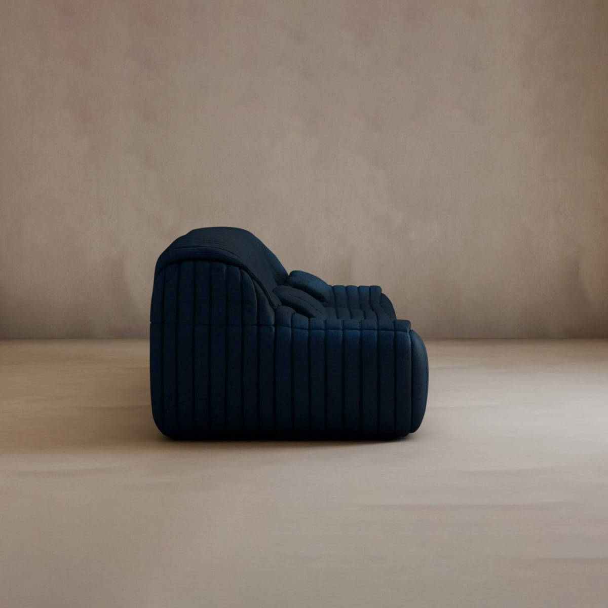 The Calypso Armchair is a plush, dark blue lounge chair with modern elegance, featuring a tufted stripe design and vertical stitching, displayed in profile against a plain beige wall and soft beige floor.