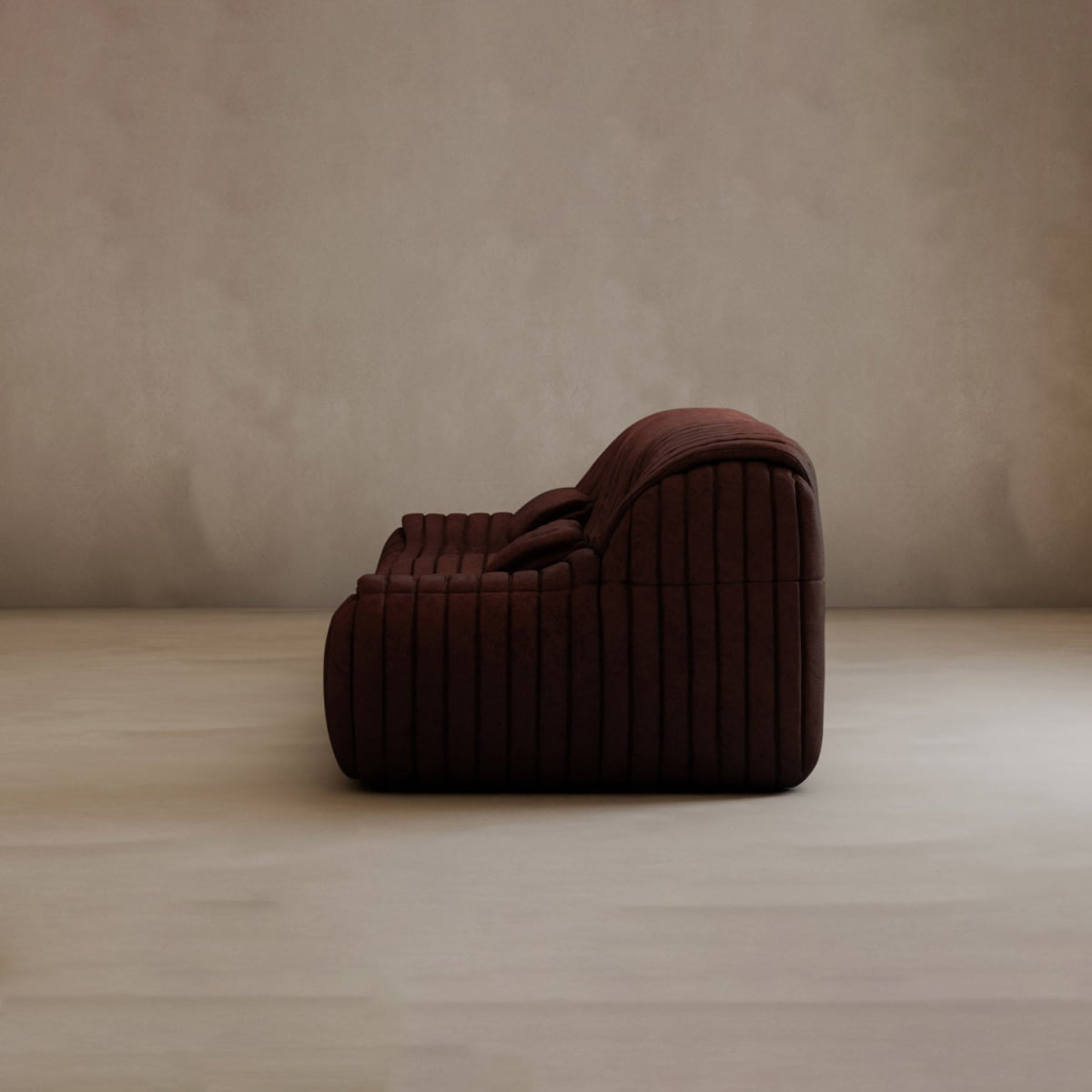 The Calypso Armchair features a modern, low-profile design with dark brown tufted upholstery, set on a light floor against a plain beige wall.
