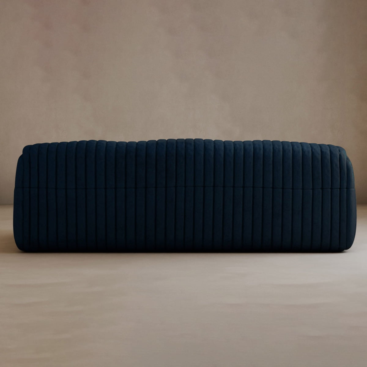 A dark blue, rectangular ottoman with a tufted stripe design sits on a neutral floor by a beige wall, adding modern elegance to any space and pairing perfectly with the Calypso Armchair.