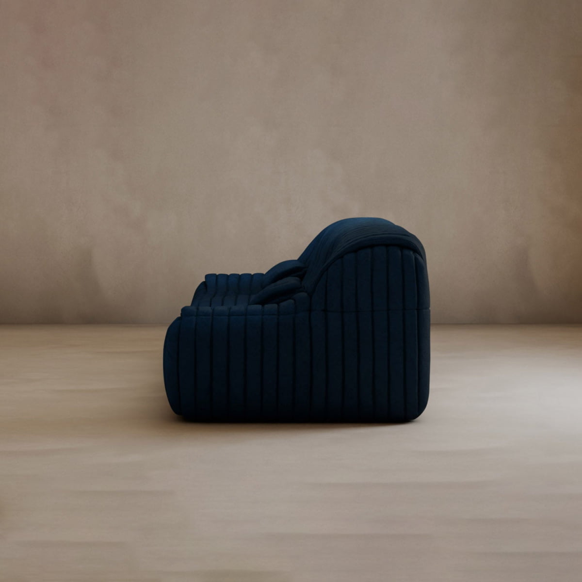 The Calypso Armchair, in dark blue with vertical stitching and a tufted stripe design, sits on a light beige floor against a neutral wall. Shown in profile facing left, it exudes modern elegance.